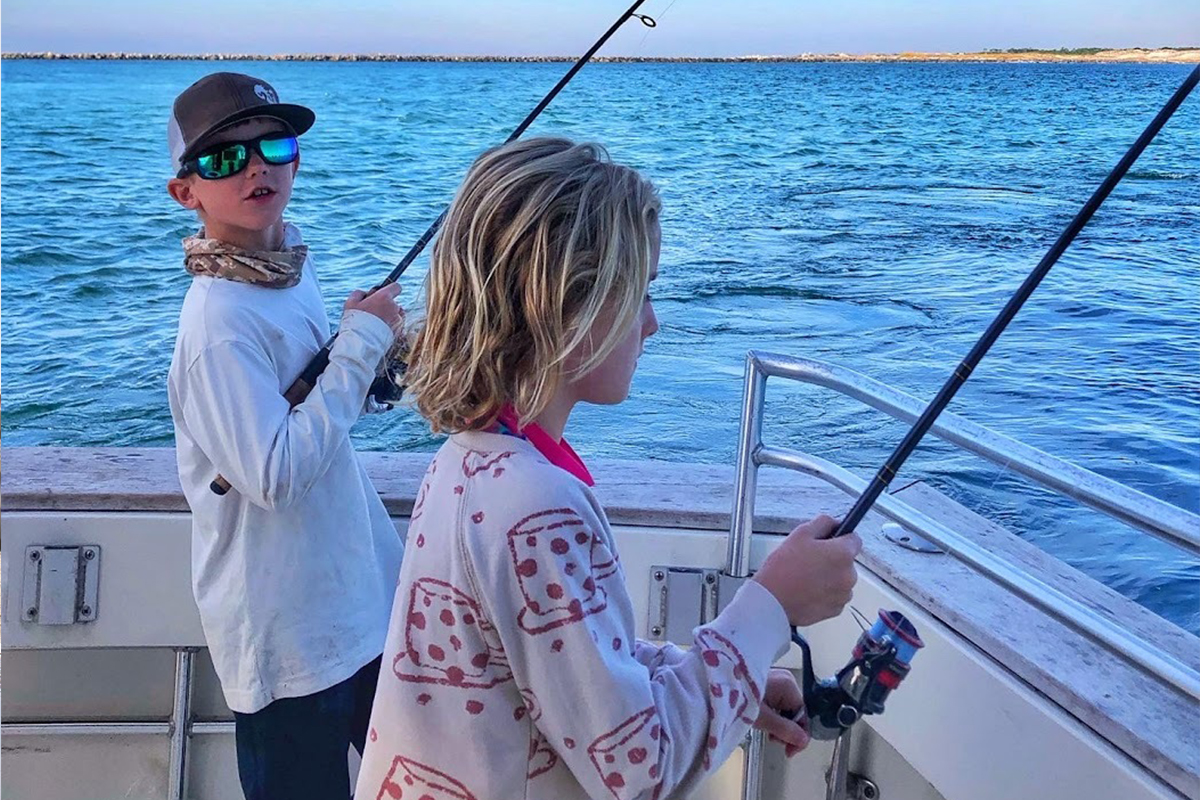 Two kids fish from boat in Gulf of Mexico