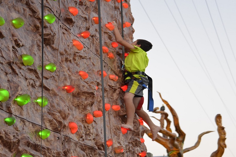 a man climbing up the side of a rock wall.