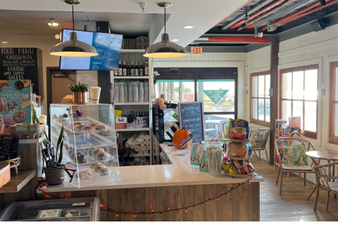 The inside of a coffee shop with a counter and shelves.