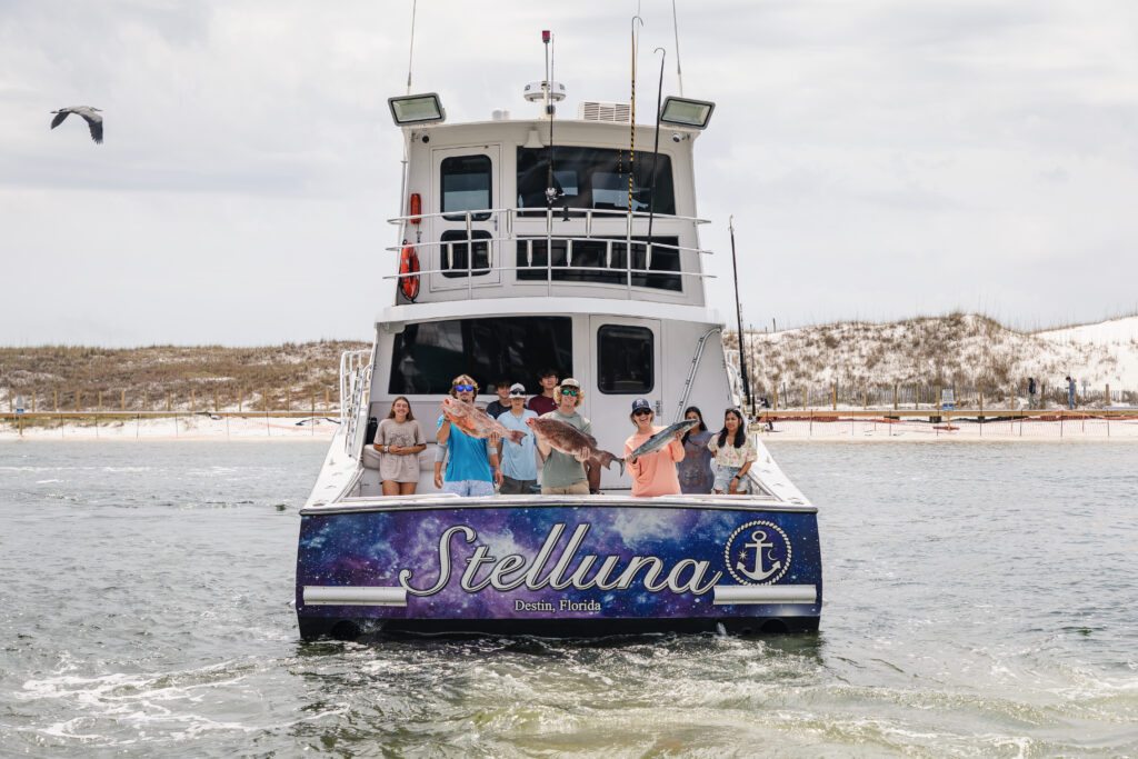 A group of people on the back deck of a boat named 