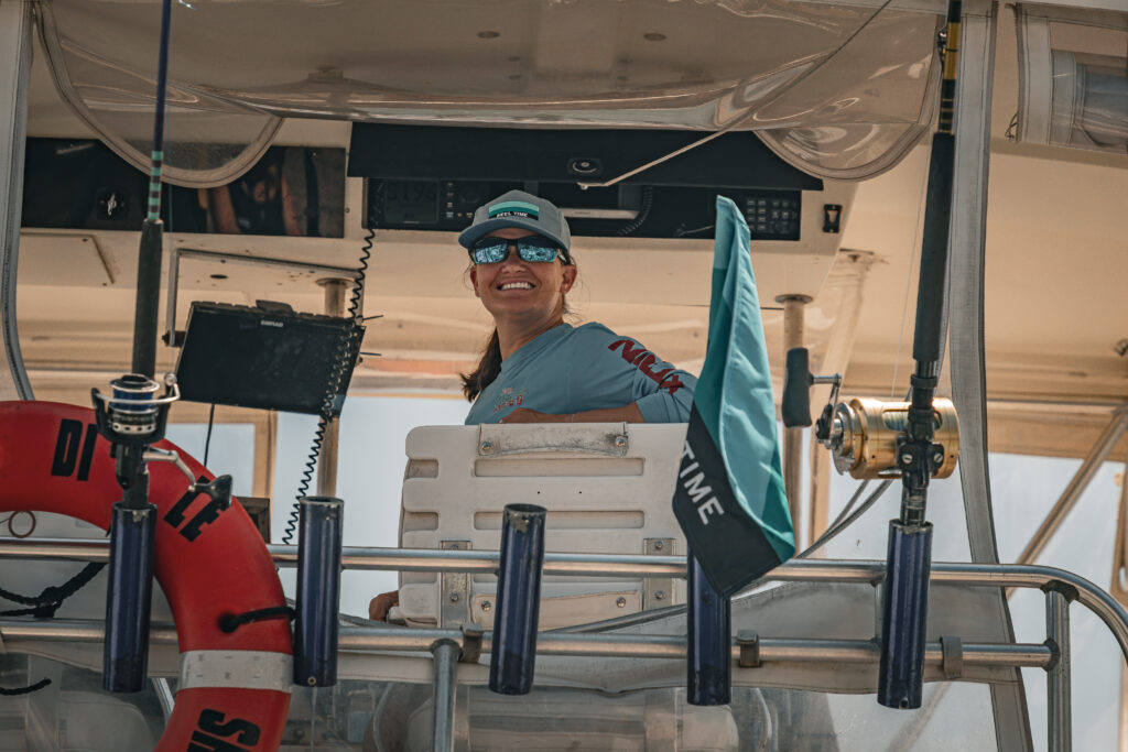 Person standing on a boat smiling at the camera