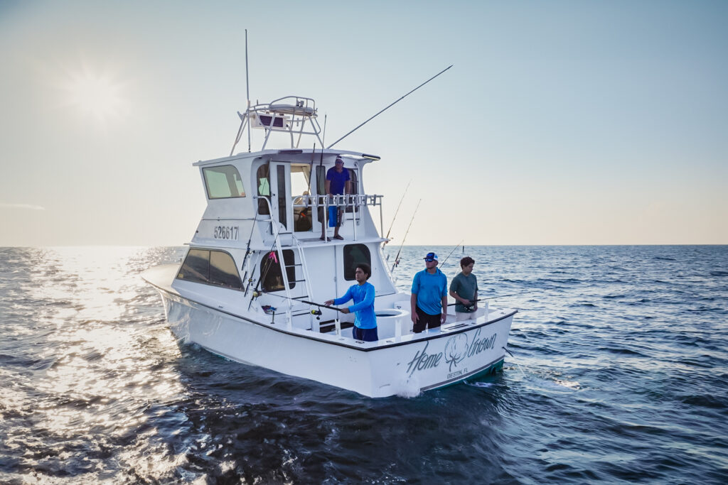 A group of people fishing on a white boat named 