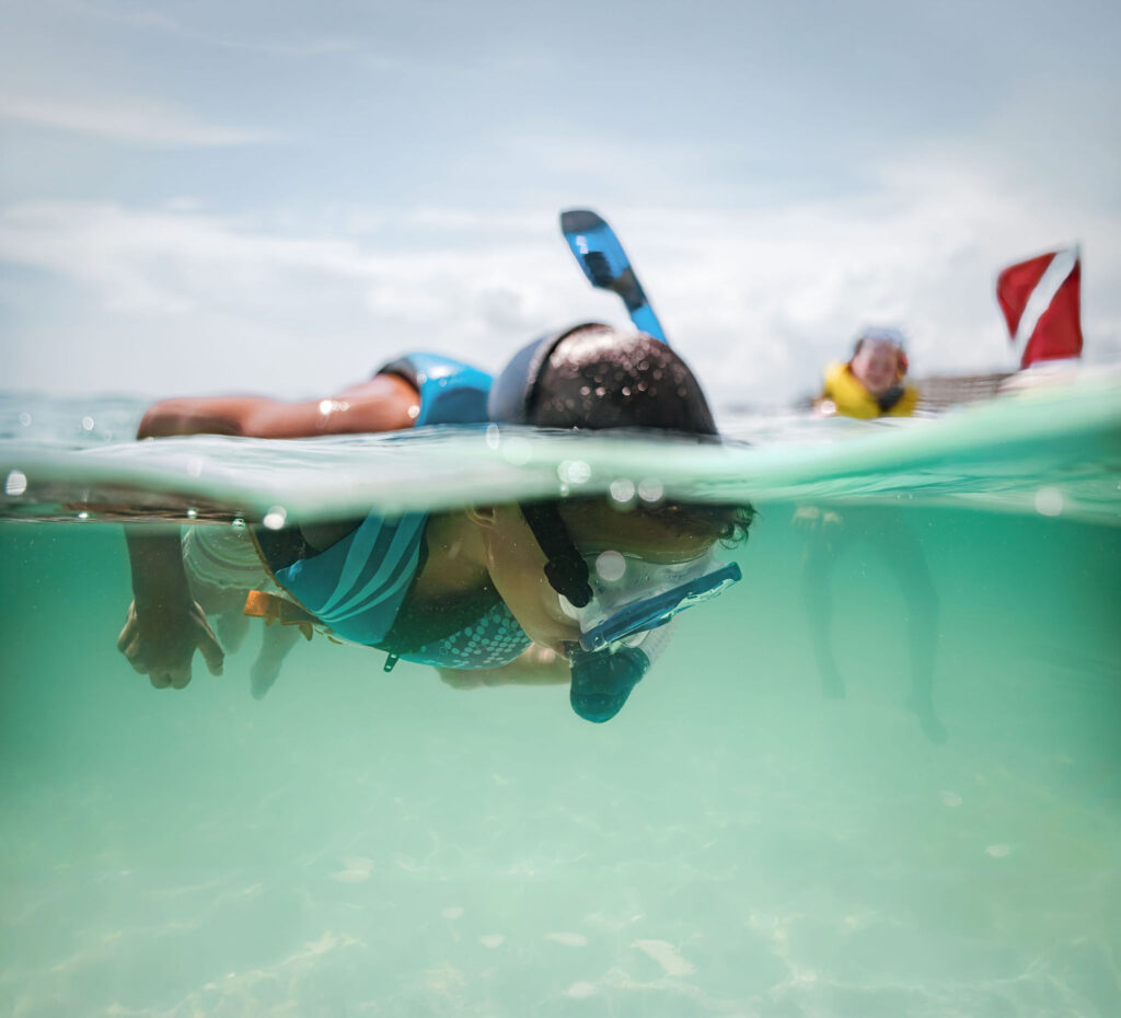 A child snokels underwater