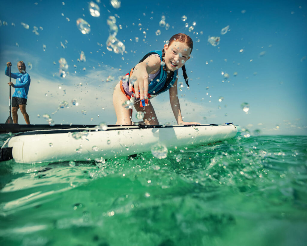 A young girl on a surfboard in the water