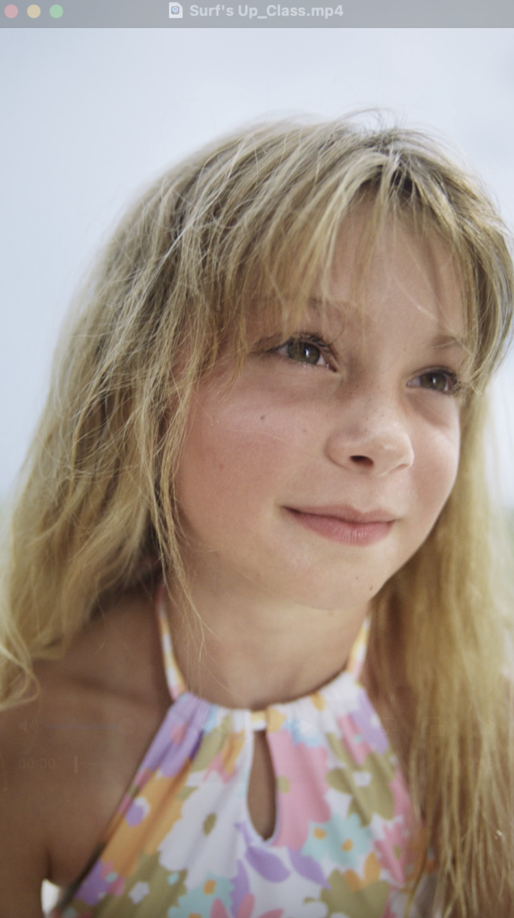 A blonde girl sits on the beach