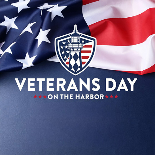 Veterans Day on the Harbor promotional image with an American flag, a lighthouse shield emblem, and bold white text on a blue background.